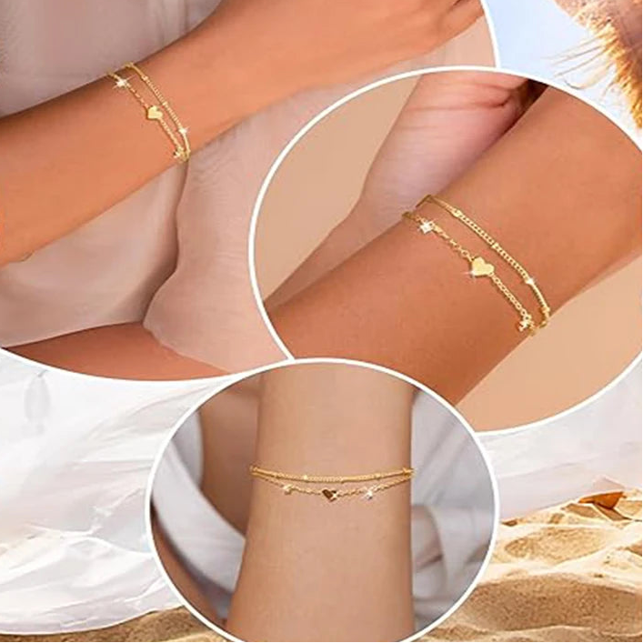 Two delicate 14k gold-plated bracelets with a heart pendant.