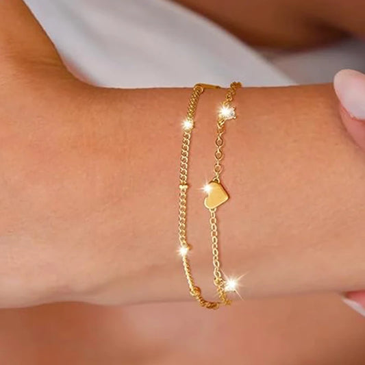 Two delicate 14k gold-plated bracelets with a heart pendant.